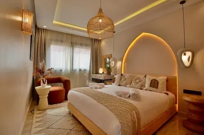 a bedroom with a large bed with an arched headboard at Central Luxury Quiet Hivernage 2 Balconies With View in Marrakech
