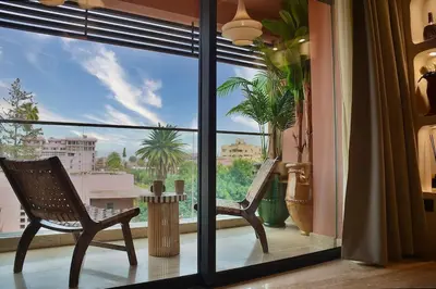 a room with a window with a chair on a balcony at Central Luxury Quiet Hivernage 2 Balconies With View in Marrakech
