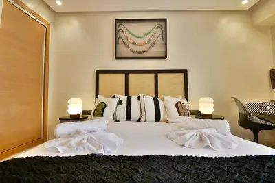 a bedroom with a large white bed with two lamps at Central Luxury Quiet Hivernage 2 Balconies With View in Marrakech