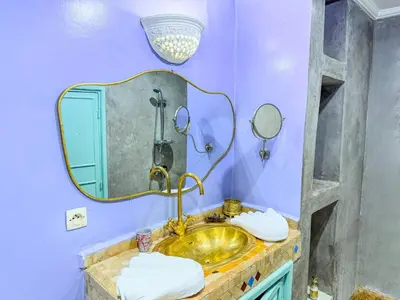 a bathroom with a gold sink and a mirror at Riad medina d'or in Marrakech