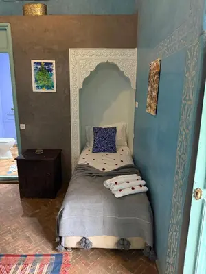 a small bedroom with a bed in the corner at Riad medina d'or in Marrakech