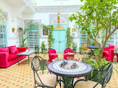 a living room with red furniture and a table at Riad medina d'or in Marrakech