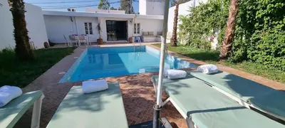 a swimming pool with two lawn chairs and a house at VILLa PALMS KECH in Marrakech