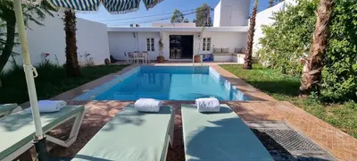 a swimming pool in the backyard of a house at VILLa PALMS KECH in Marrakech