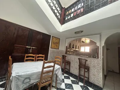 a dining room with a table and chairs and a mirror at Riad Al Hanaa in Marrakech