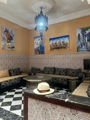 a room with couches and a hat on a table at Riad Al Hanaa in Marrakech