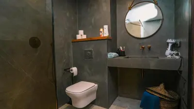 a bathroom with a toilet and a sink and a mirror at Appartement chaleureux agréable pour des vacances en famille in Marrakech