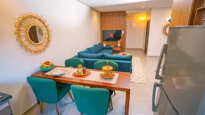 a living room with a table and a blue couch at Appartement chaleureux agréable pour des vacances en famille in Marrakech