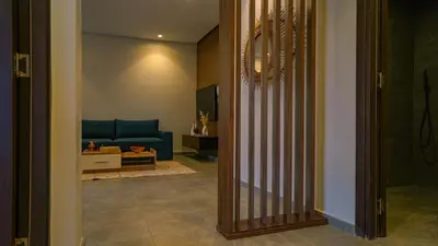 a hallway leading to a living room with a blue couch at Appartement chaleureux agréable pour des vacances en famille in Marrakech