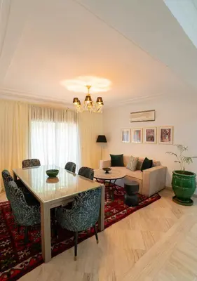 a living room with a table and a couch at Un magnifique appartement avec jardin à Marrakech in Marrakech