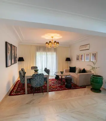 a living room with a couch and a table at Un magnifique appartement avec jardin à Marrakech in Marrakech