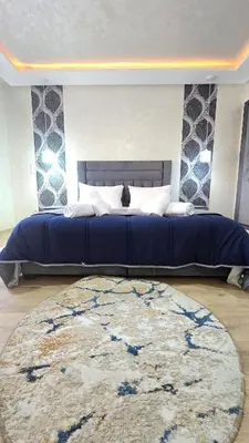 a bedroom with a large blue bed and a rug at Luxury Penthouse and Jacuzzi at Hivernage in Marrakech