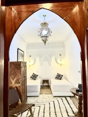 a living room with two beds and a chandelier at Riad Serendip in Marrakech