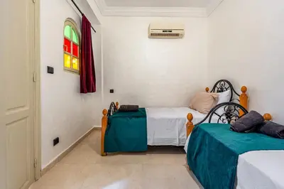 a bedroom with two beds and a window at New Stylish Riad - 4BR with Pool Access in Marrakech