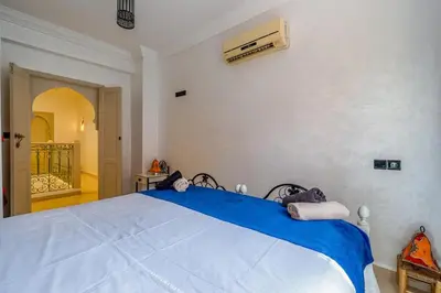 a bedroom with a large bed with blue sheets at New Stylish Riad - 4BR with Pool Access in Marrakech