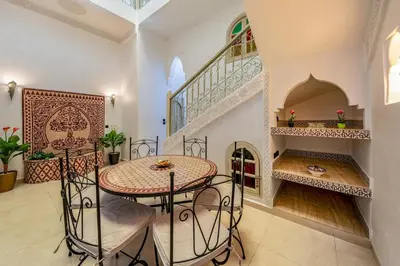 a dining room with a table and a staircase at New Stylish Riad - 4BR with Pool Access in Marrakech
