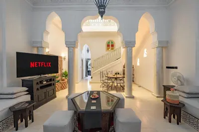 a living room with a tv and a couch and a table at New Stylish Riad - 4BR with Pool Access in Marrakech