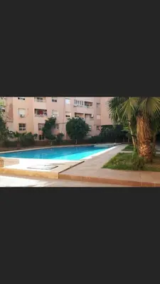 a large swimming pool in front of a building at Appart 2 CH lumineux et une piscine pour votre séjour in Marrakech
