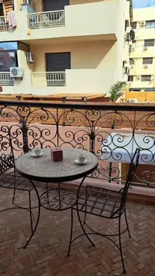 a table and two chairs on a balcony at Appartement tres aimable in Marrakech
