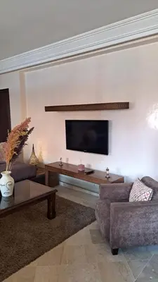 a living room with two couches and a flat screen tv at Appartement tres aimable in Marrakech