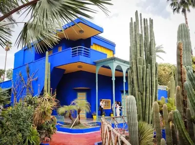a blue house with cacti in front of it at Appartement tres aimable in Marrakech