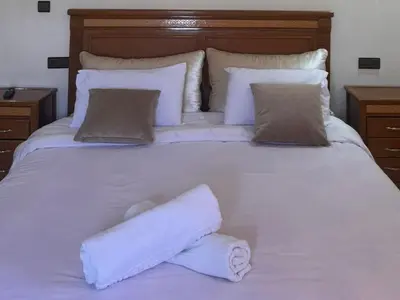 a large white bed with two rolled towels on it at Villa cosy & pool Marrakech in Marrakech