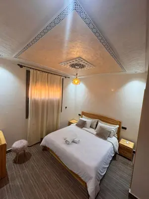 a bedroom with a large bed with white sheets at Villa cosy & pool Marrakech in Marrakech