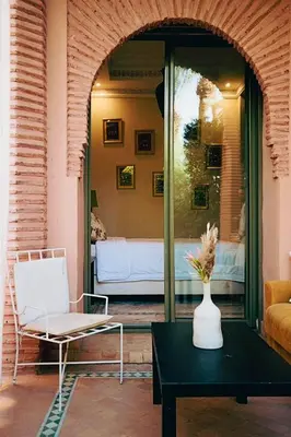 a living room with a couch and a vase on a table at Palmeraie - Open Garden & Pool in Marrakech