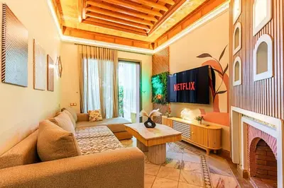 a living room with a couch and a tv at Palmeraie - Open Garden & Pool in Marrakech