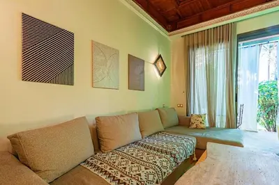 a living room with a couch and a large window at Palmeraie - Open Garden & Pool in Marrakech