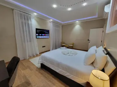 a bedroom with a white bed and a tv on the wall at Villa Marrakech Rimass - 6 Chambres Dont 5 Suites Luxe, Piscine Privee & Jardins in Marrakech