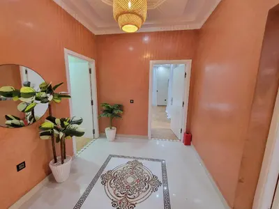 a hallway with orange walls and a white floor at Villa Marrakech Rimass - 6 Chambres Dont 5 Suites Luxe, Piscine Privee & Jardins in Marrakech