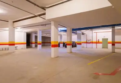 an empty parking garage with white columns and colorful stripes at Luxury Aprt 2-bedrooms-Pool Hivernage City Centre-Free Parking in Marrakech