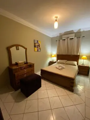 a bedroom with a bed and a dresser and a mirror at Youssef House Le Village Touristique in Marrakech