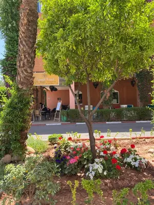 a garden with flowers in front of a building at Youssef House Le Village Touristique in Marrakech