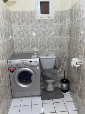 a bathroom with a washing machine and a toilet at Youssef House Le Village Touristique in Marrakech