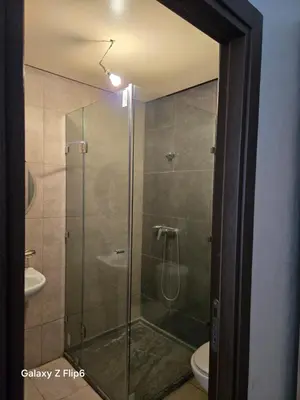 a glass shower in a bathroom with a toilet at APPARTEMENT à TARGA in Marrakech