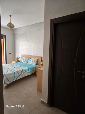 a bedroom with a bed and a black door at APPARTEMENT à TARGA in Marrakech