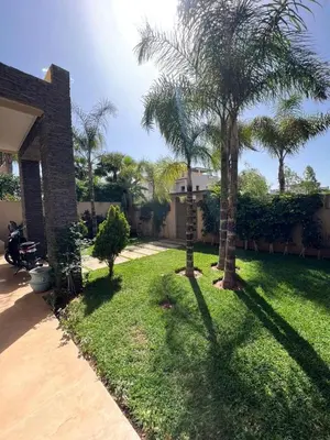 a yard with two palm trees and a house at Private Villa with Pool in Marrakech