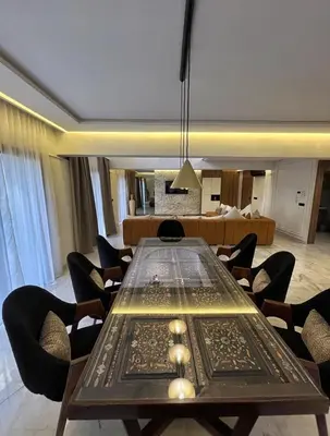 a dining room with a table and chairs and a couch at Luxury Serenity Marrakech - Spacious Duplex with Pool in Marrakech