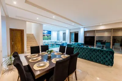 a dining room with a table and chairs and a couch at Villa 3 in Marrakech