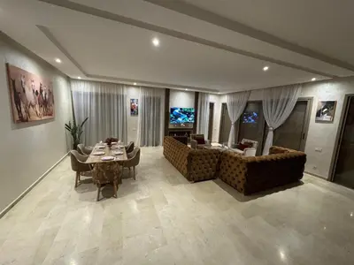 a living room with a couch and a table with chairs at Villa 5 in Marrakech