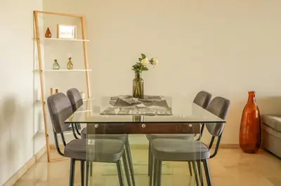a dining room table with chairs and a vase on it at Luxury golf Prestigia Saphir in Marrakech
