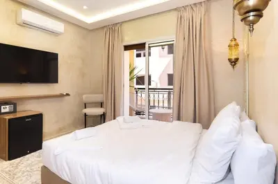a bedroom with a white bed and a balcony at Suite Jasmin Elegance a Gueliz in Marrakech
