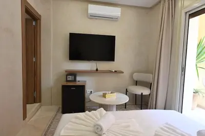 a hotel room with a bed and a television on the wall at Suite Jasmin Elegance a Gueliz in Marrakech