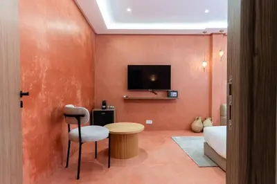 a living room with a bed and a tv on a wall at Suite Sirocco - Confort a Gueliz in Marrakech