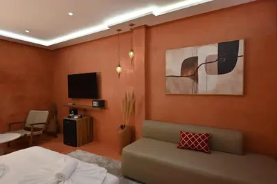 a bedroom with a bed and a couch and a tv at Suite Sirocco - Confort a Gueliz in Marrakech