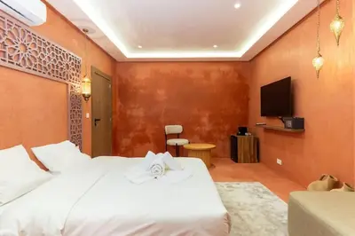 a bedroom with a white bed and a tv at Suite Sirocco - Confort a Gueliz in Marrakech