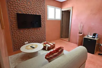 a living room with a couch and a tv on a wall at Suite Safran - Ambiance berbere in Marrakech