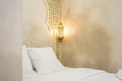 a bed with a white pillow and a mirror at Suite Dune - Confort et Elegance in Marrakech